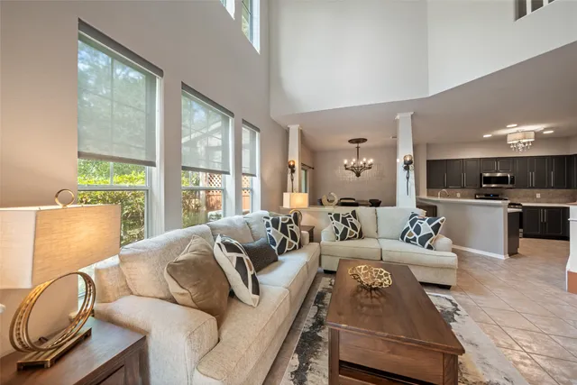 a living room with furniture a fireplace and a large window