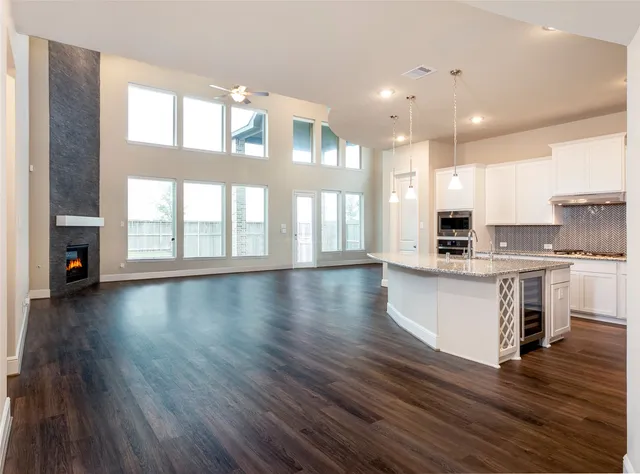 a view of kitchen with kitchen island wooden floors and stainless steel appliances