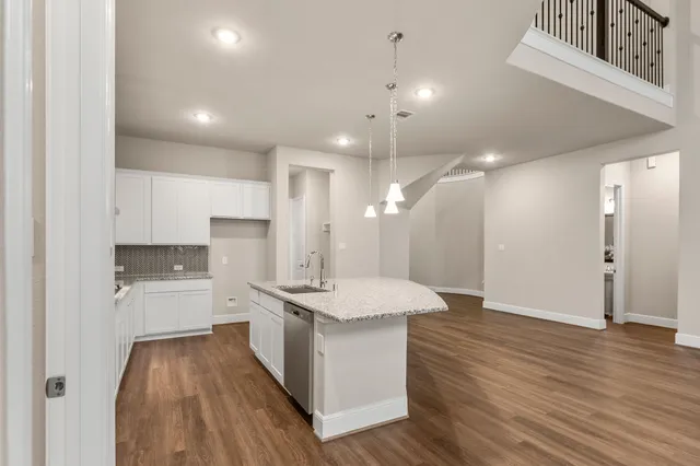 an open kitchen with a sink and stainless steel appliances