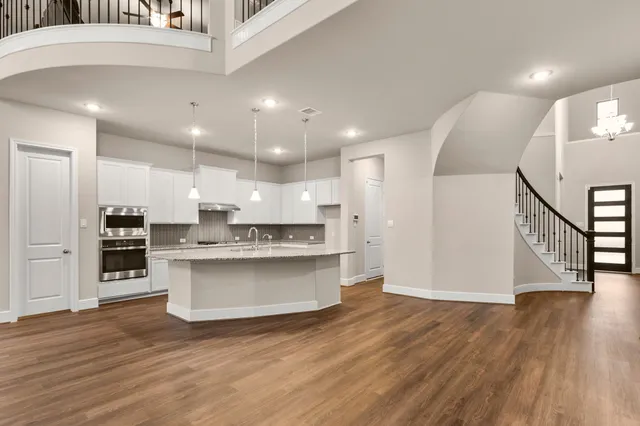 a view of kitchen with stainless steel appliances refrigerator stove microwave and cabinets