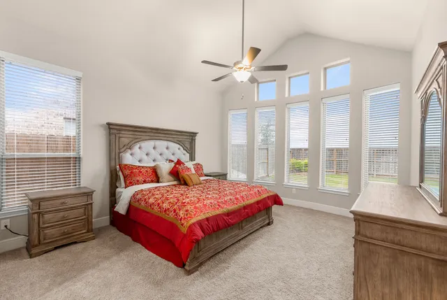 a bedroom with a bed and a dresser next to a window