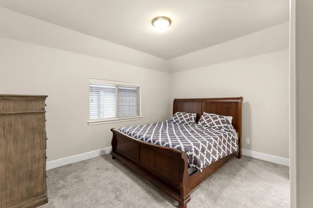 a bed sitting in a bedroom next to a window