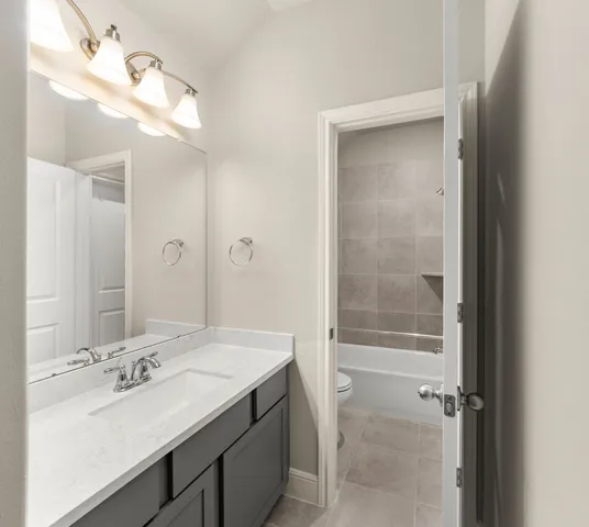a bathroom with a sink vanity granite tub and shower