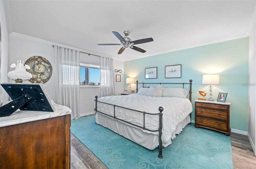8251 Brent Street, Unit 912 Port Richey, FL 34668 - Photo 16 of 84 a bedroom with a bed and a chandelier