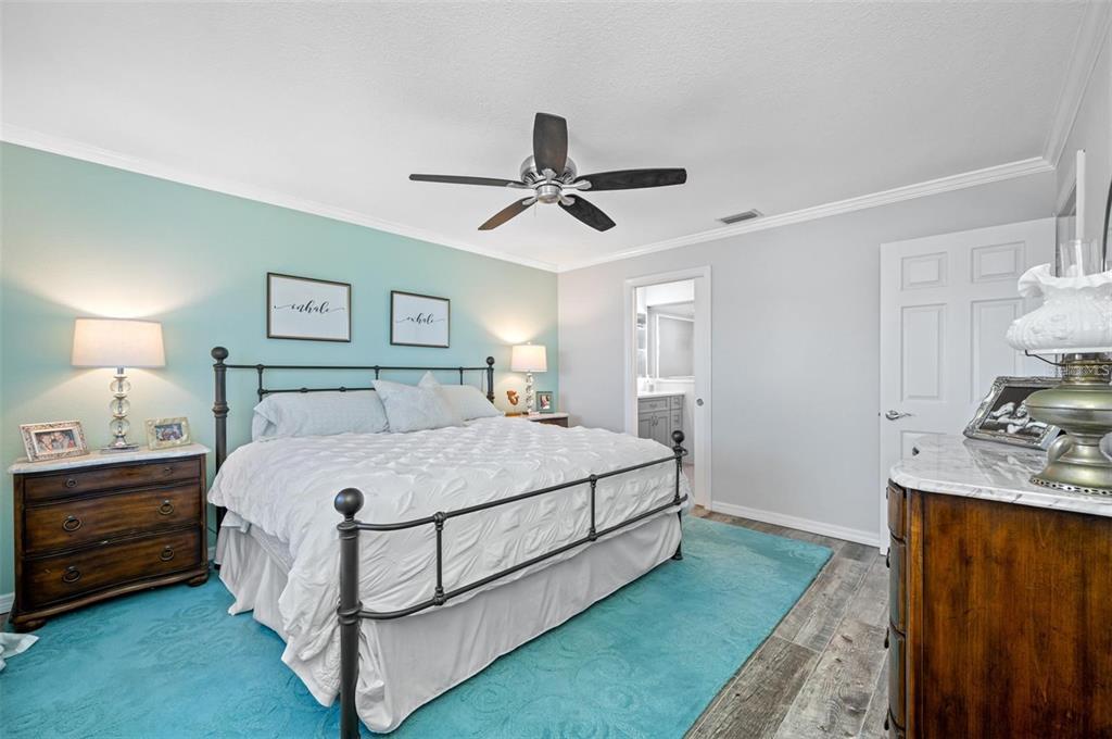 8251 Brent Street, Unit 912 Port Richey, FL 34668 - Photo 17 of 84 a spacious bedroom with a bed and a chandelier