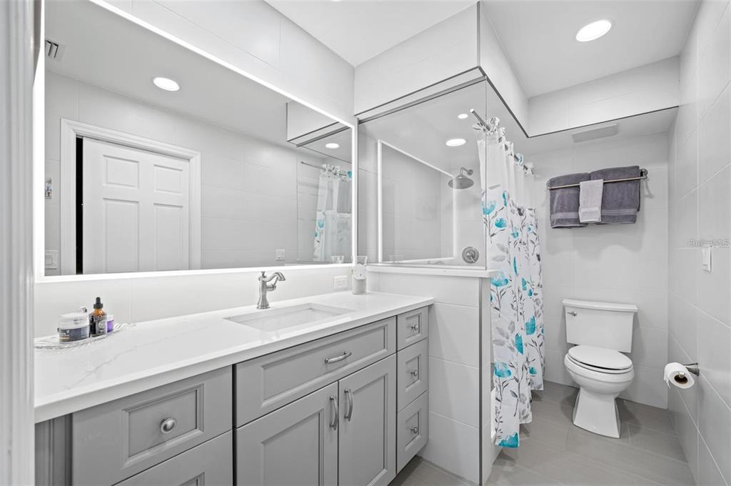 8251 Brent Street, Unit 912 Port Richey, FL 34668 - Photo 18 of 84 a bathroom with a granite countertop sink a toilet and a mirror