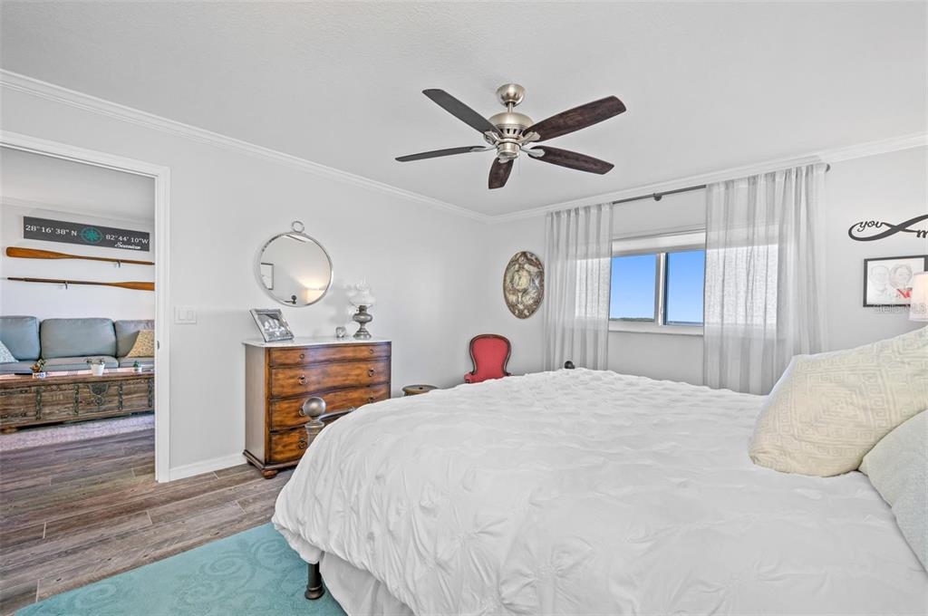 8251 Brent Street, Unit 912 Port Richey, FL 34668 - Photo 79 of 84 a bedroom with a bed and dresser with wooden floor