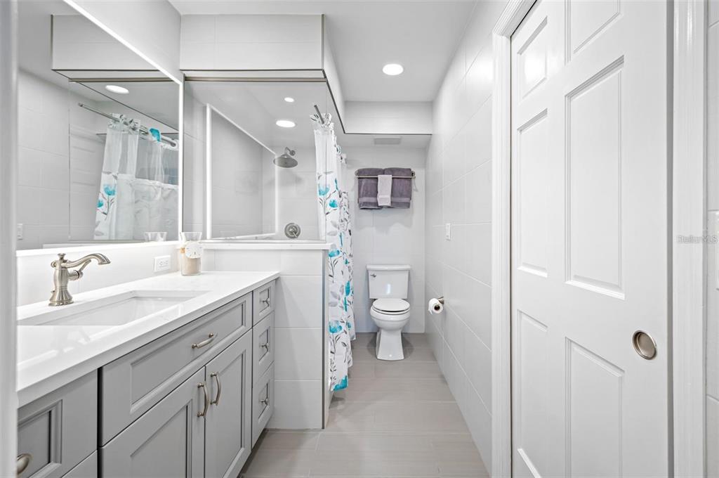 8251 Brent Street, Unit 912 Port Richey, FL 34668 - Photo 81 of 84 a spacious bathroom with a double vanity sink a mirror and a toilet