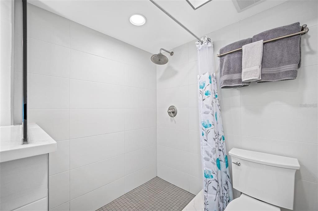 8251 Brent Street, Unit 912 Port Richey, FL 34668 - Photo 82 of 84 a bathroom with a shower curtain and a toilet