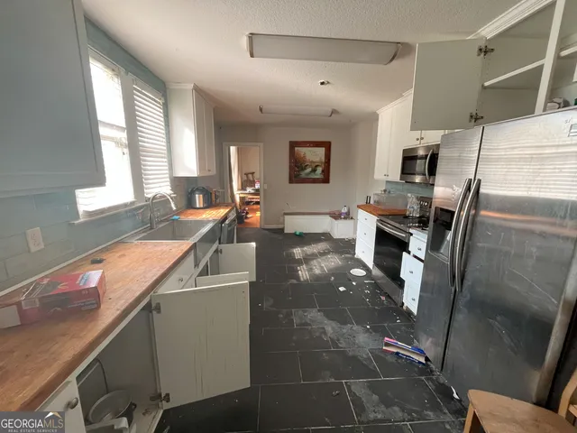 a kitchen with stainless steel appliances granite countertop a sink a stove and a refrigerator