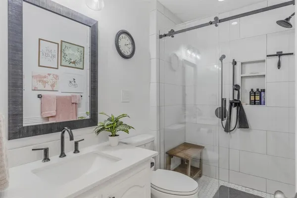a bathroom with a sink vanity mirror and toilet