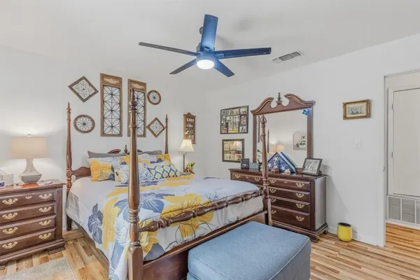 a bedroom with bed and paintings on the wall