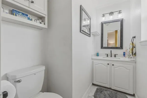 a bathroom with a toilet sink and mirror