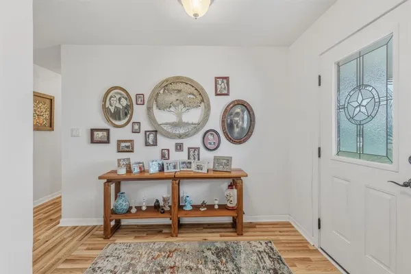 a living room with chair and a clock on wall