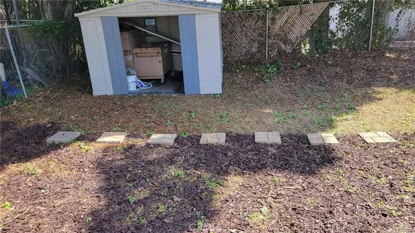 a view of a backyard with table and chairs potted plants