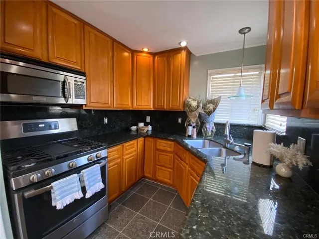 a kitchen with stainless steel appliances a stove a sink and cabinets