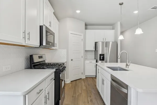 a kitchen with stainless steel appliances a sink stove and refrigerator
