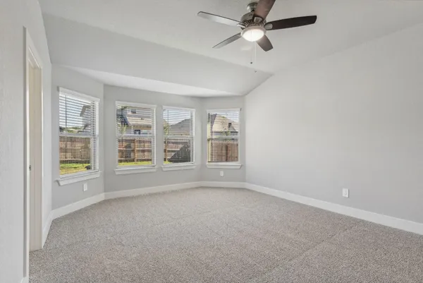 a view of an empty room with a window and kitchen view