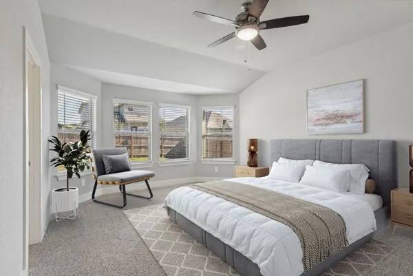 a bedroom with a bed couches and potted plant on the dresser