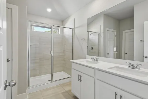 a bathroom with a shower sink vanity and mirror