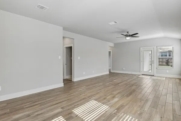 a view of an empty room with wooden floor