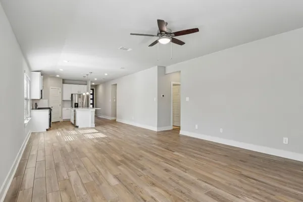 a view of a livingroom with a hardwood floor and a ceiling fan