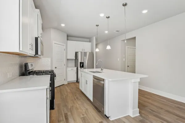 a kitchen with white cabinets and stainless steel appliances