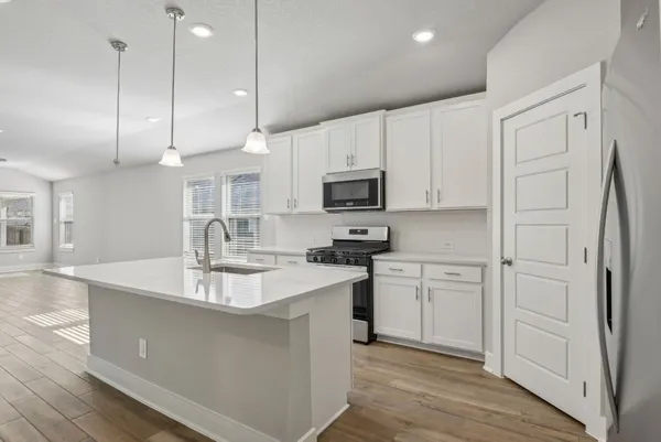 a kitchen with kitchen island white cabinets and stainless steel appliances