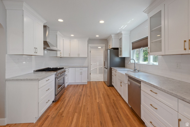 1214 North 300 West Mapleton, UT 84664 - Photo 7 of 33 Modern kitchen featuring newer white shaker cabinetry, new commercial gas range, newer refrigerator and dishwasher, a subway tile backsplash, light-toned countertops, and wood-finish flooring