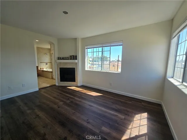 a view of an empty room with a fireplace and a window