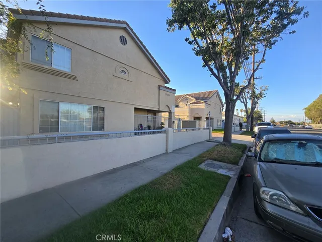 a view of a white house with a large tree