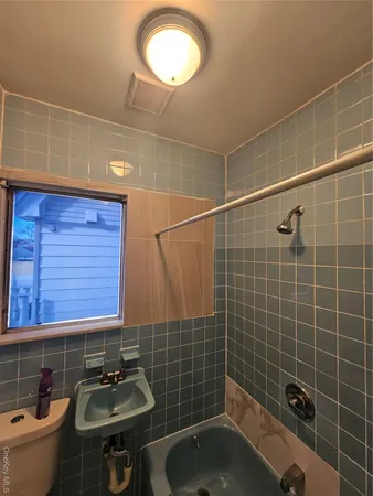 a bathroom with a sink a toilet a mirror and shower