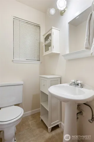 a bathroom with a sink a toilet and mirror