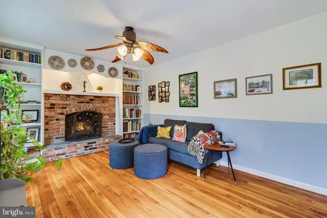a dining room with furniture a large window and wooden floor