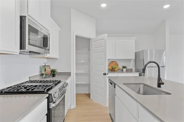 a kitchen with stainless steel appliances granite countertop a sink and a stove top oven