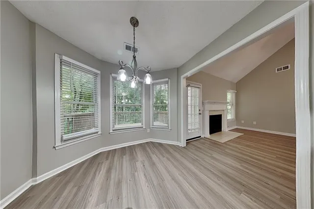 a view of empty room with wooden floor and fireplace