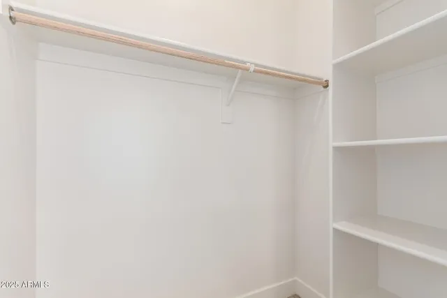 a view of walk in closet with empty racks