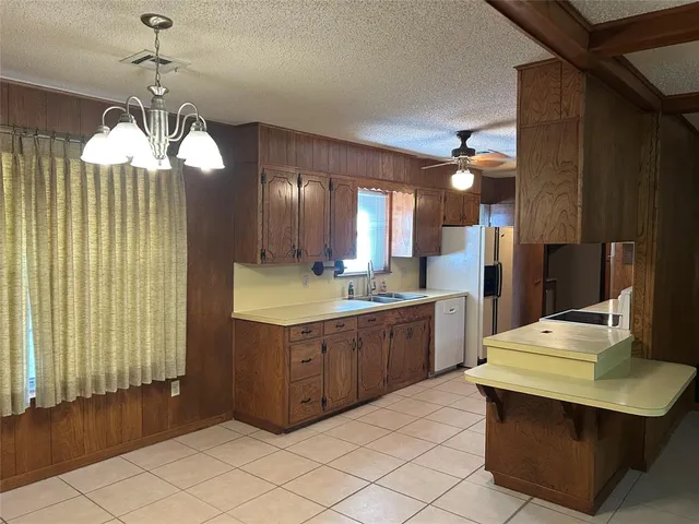 a kitchen with stainless steel appliances kitchen island granite countertop a sink refrigerator and cabinets