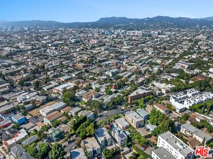 an aerial view of residential houses with outdoor space and trees