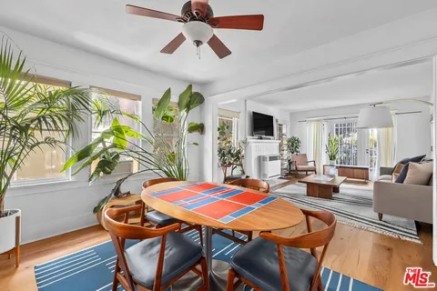 a living room with patio furniture and a potted plant