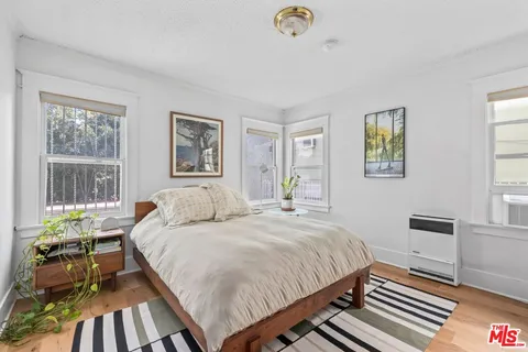 a bedroom with a bed and wooden floor