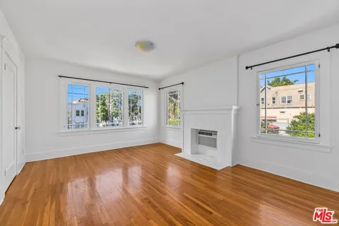 an empty room with windows and fireplace