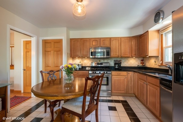 999 Shermer Road Northbrook, IL 60062 - Photo 7 of 17 a kitchen with stainless steel appliances a table chairs sink and cabinets