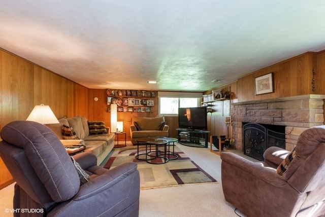 999 Shermer Road Northbrook, IL 60062 - Photo 8 of 17 a living room with furniture potted plant a fireplace and a large window