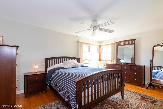 999 Shermer Road Northbrook, IL 60062 - Photo 9 of 17 a bedroom with a bed and a chandelier