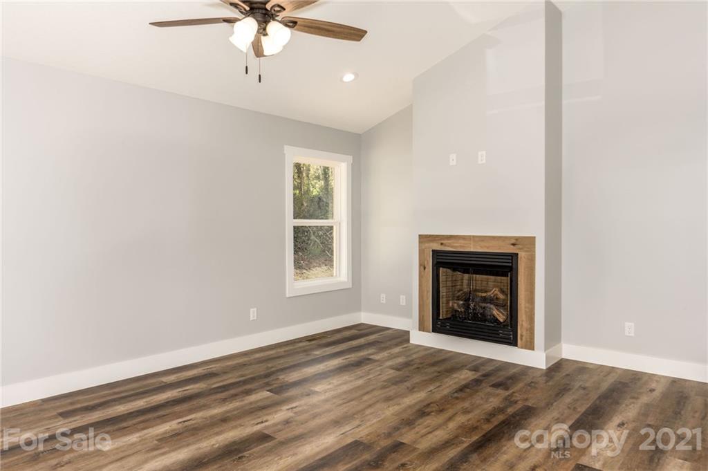 5 Sharptown Road Canton, NC 28716 - Photo 7 of 22 an empty room with a fireplace and windows