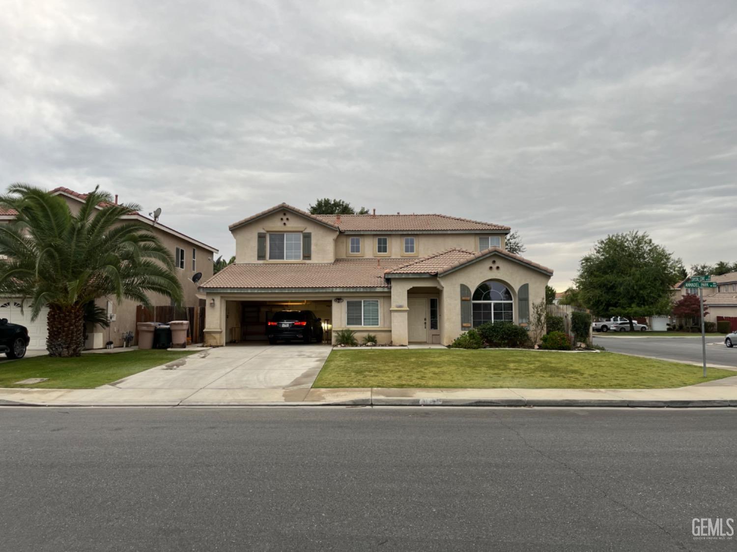 a front view of a house with a garden and trees
