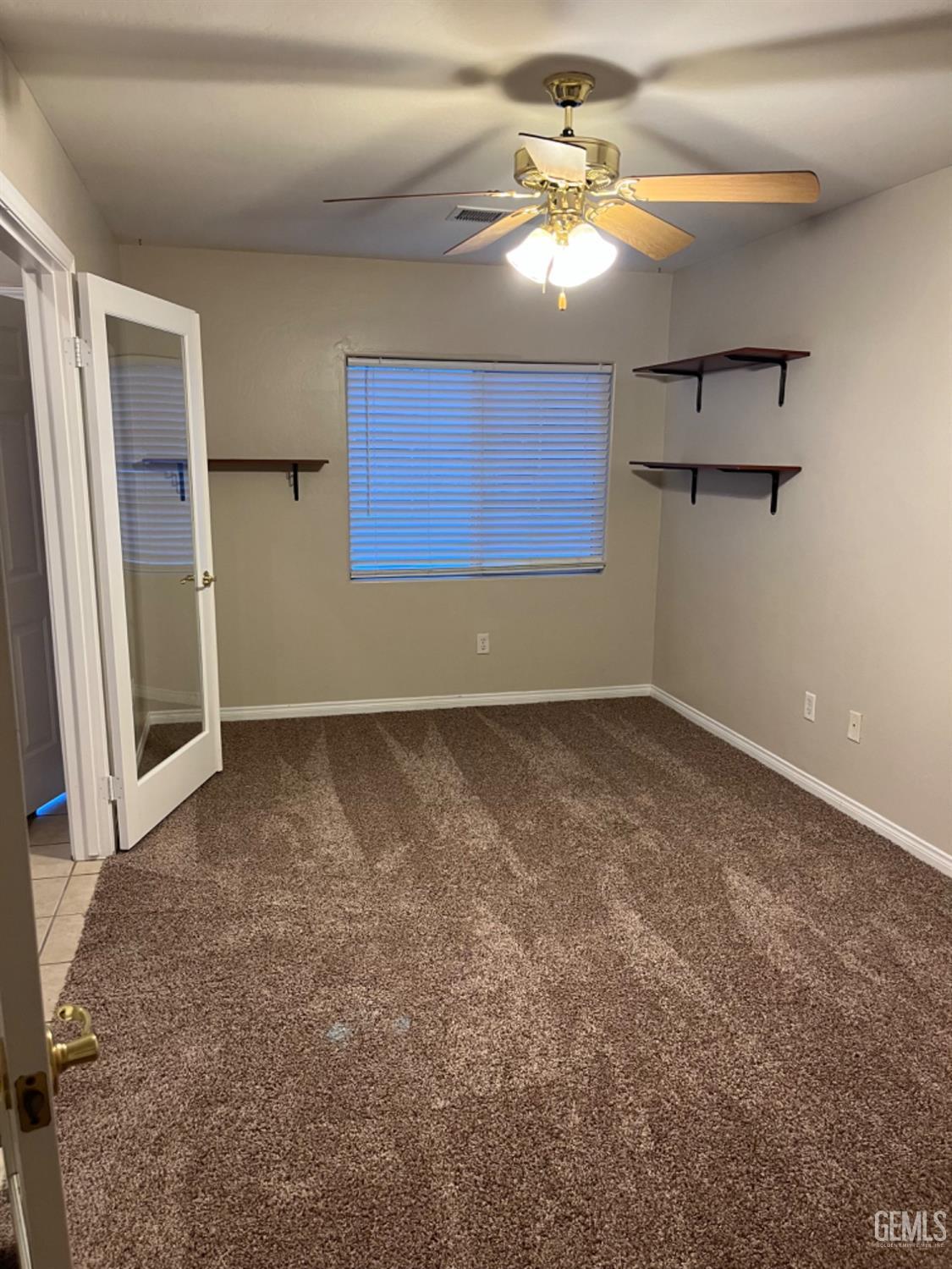 Undisclosed Address Bakersfield, CA 93311 - Photo 4 of 19 an empty room with windows and fan