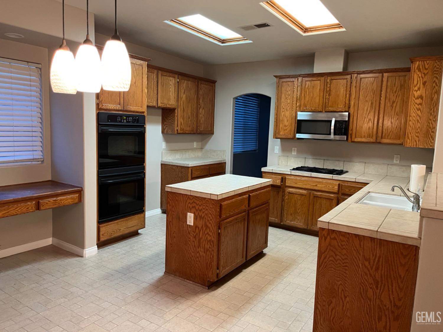 Undisclosed Address Bakersfield, CA 93311 - Photo 5 of 19 a kitchen with stainless steel appliances a stove refrigerator sink and microwave