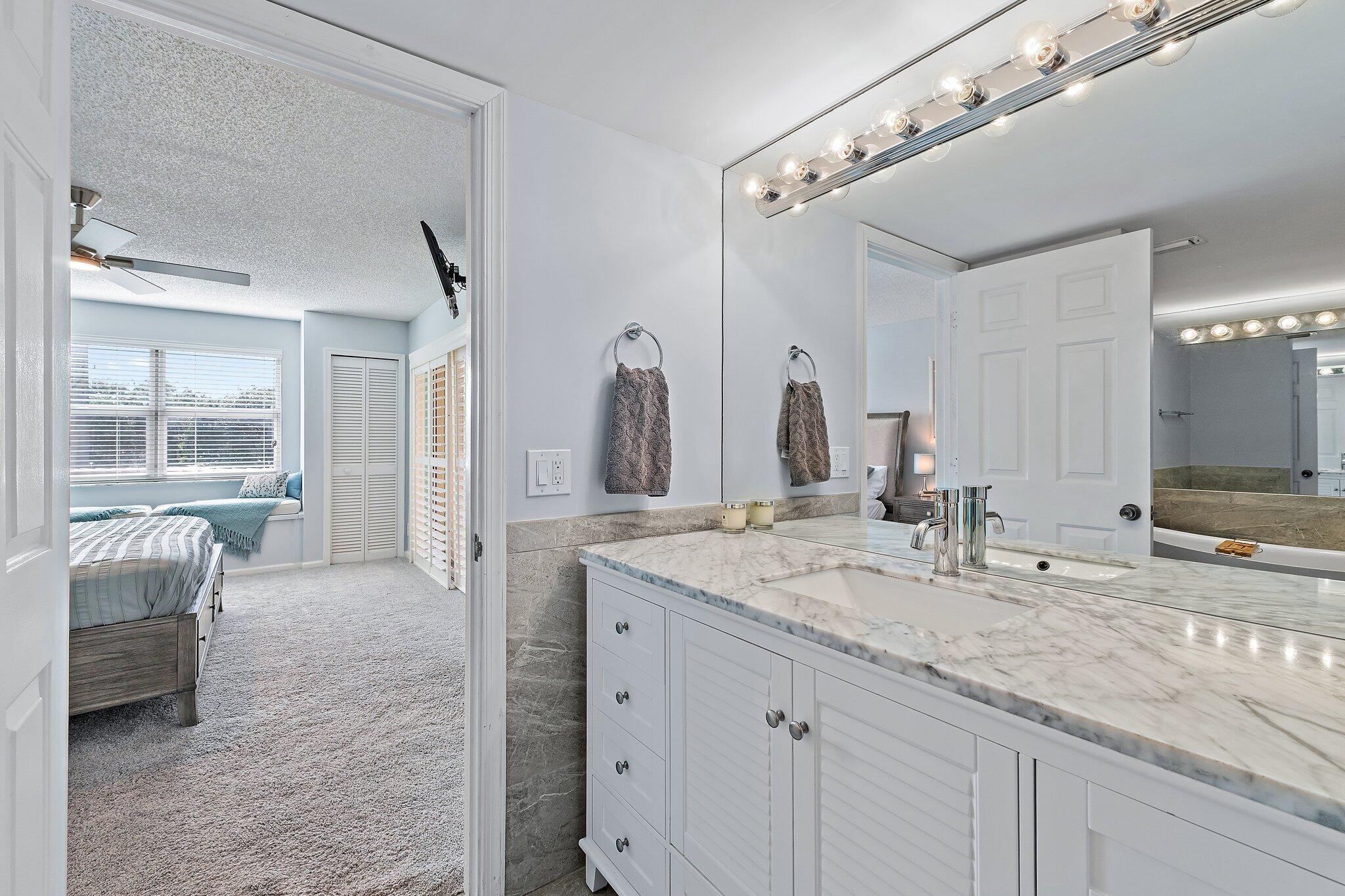 4161 U.S. Highway 1, Unit G3 Jupiter, FL 33477 - Photo 31 of 71 a bathroom with a granite countertop sink and a mirror
